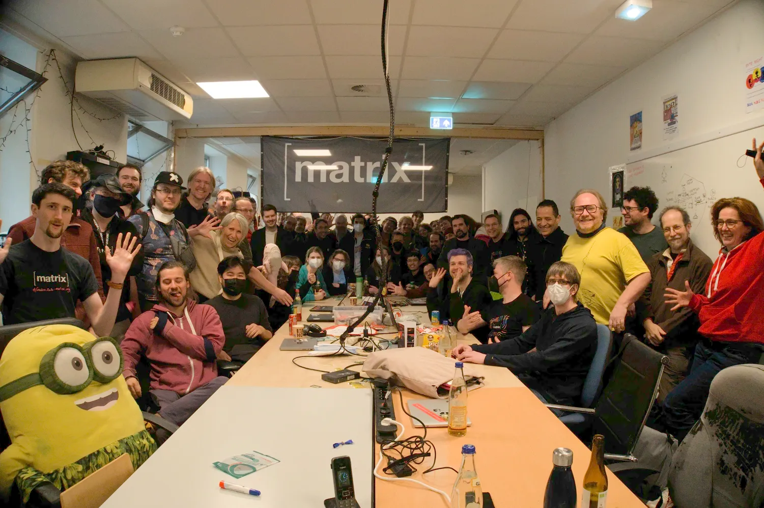 A picture of a group of people smiling and laughing in front of the Matrix flag
